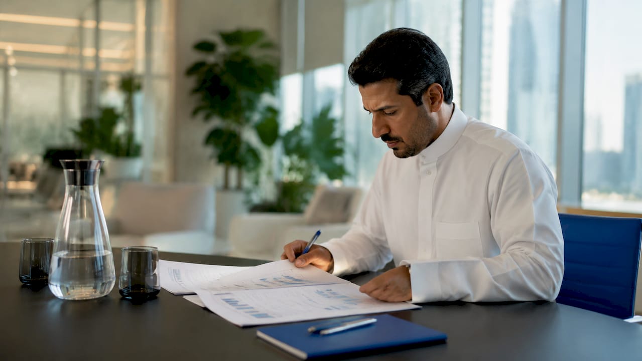 Middle Eastern business leader reviewing improvement process documents