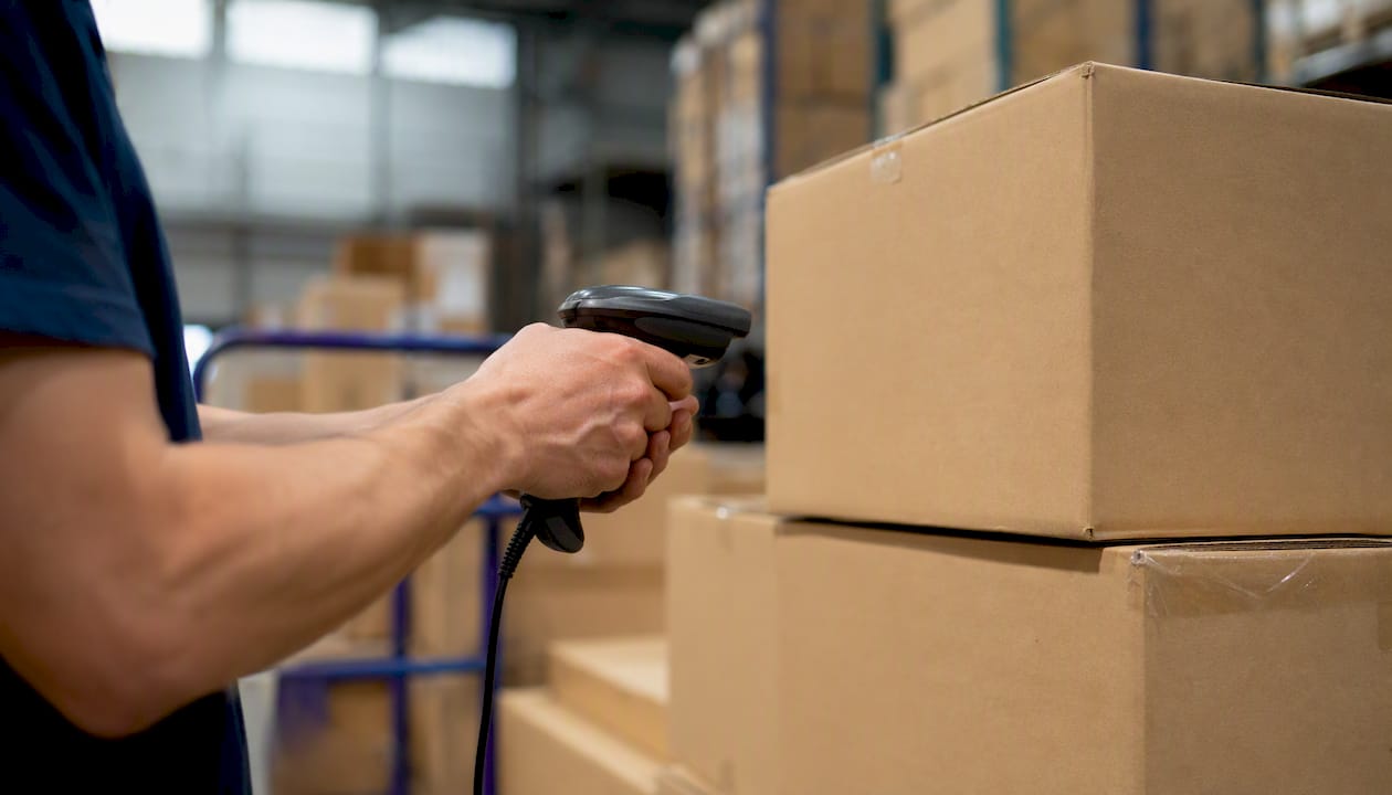 Hands scanning packages in warehouse