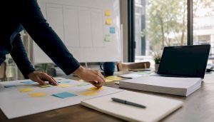 Workspace with project planning tools and hand placing notes
