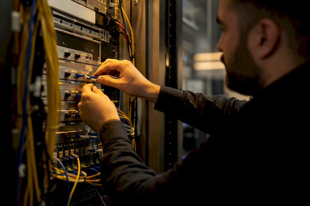 Hands connecting cables in telecom server room