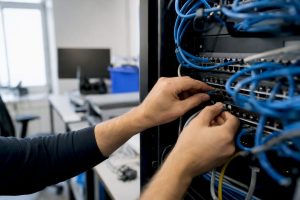 Hands connecting cables in data center