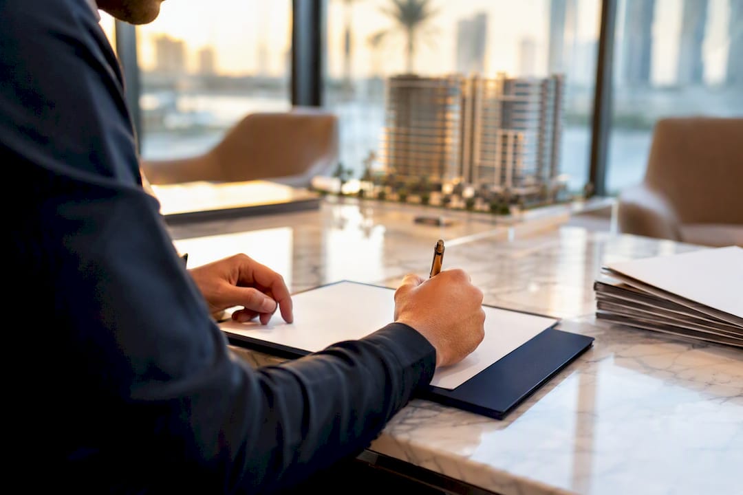 Hands filling off-plan property reservation form